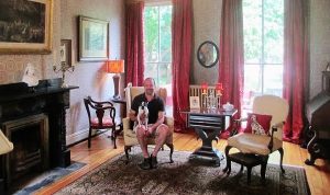 William Lipps and his Boston terrier, Ena, enjoy the home's formal parlor. Photo by Brandy Brubaker.