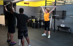 A trainer works with a two-person class in the new CrossFit gym. 